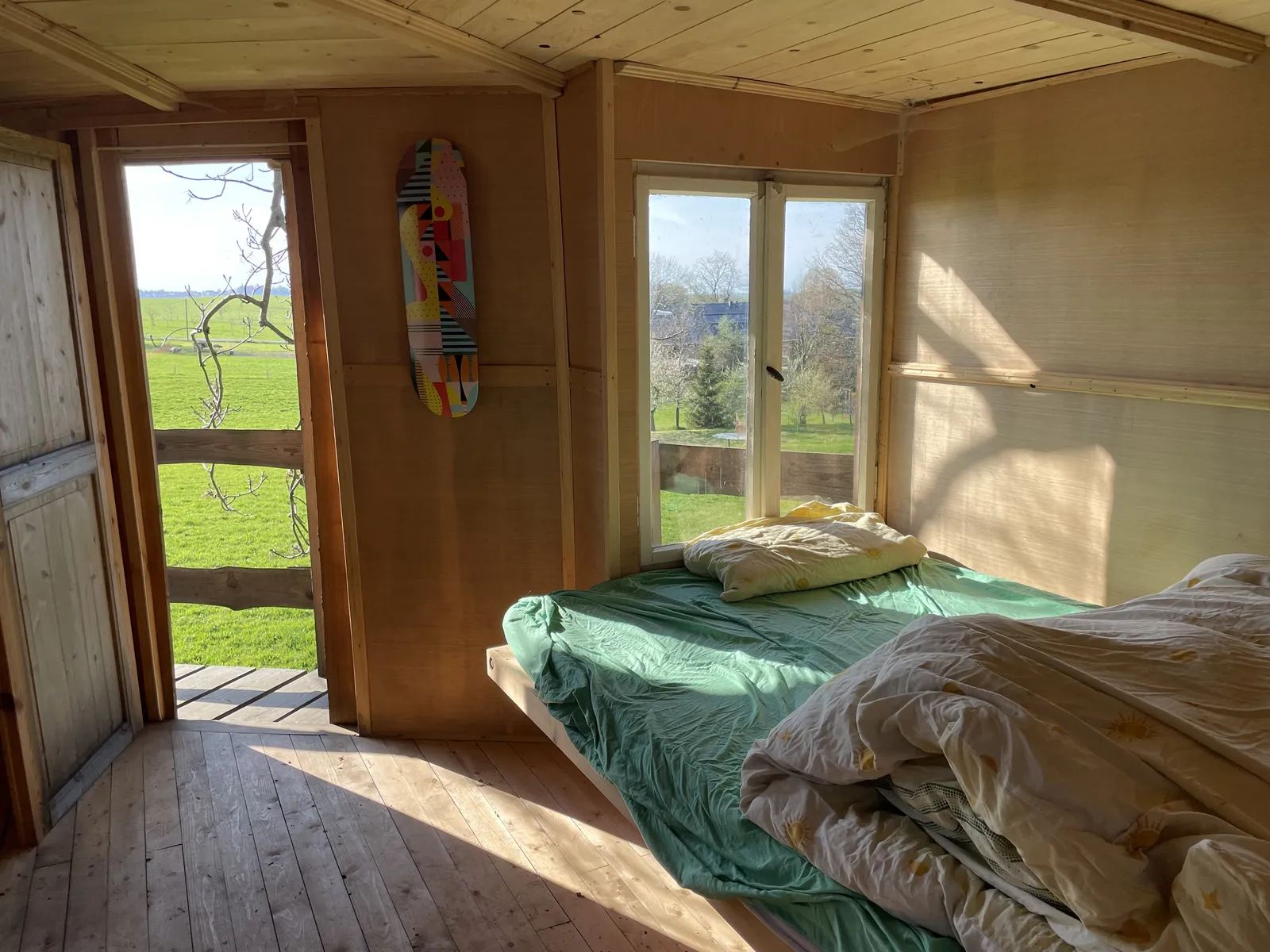 Bett im Baumhaus mit Blick in die Wiese